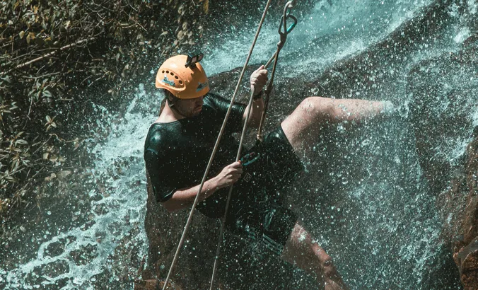 Homme Descendant en rapel dans une cascade